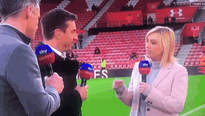 A Man And A Woman Are Talking On A Soccer Field With Microphones That Say Sky Sports On Them GIF