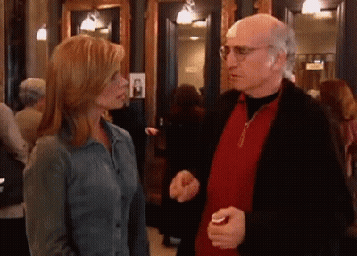 A Man And A Woman Are Talking To Each Other In A Crowded Room GIF