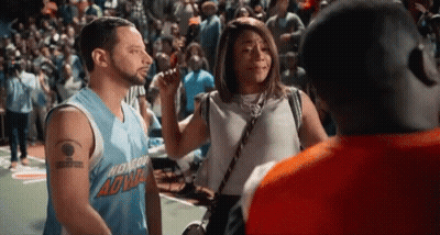 A Man And A Woman Are Talking To Each Other On A Basketball Court . GIF