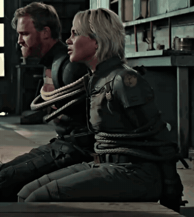 A Man And A Woman Are Tied Up With Ropes In A Room GIF