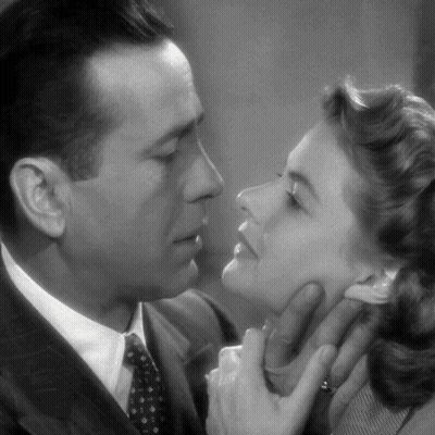 A Man And A Woman Are Touching Each Other 'S Faces In A Black And White Photo GIF