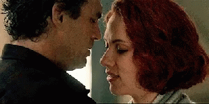 A Man And A Woman Are Touching Their Foreheads And Looking At Each Other . GIF