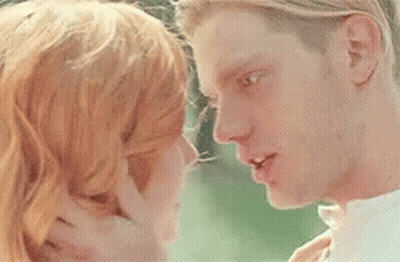 A Man And A Woman Are Touching Their Foreheads And Smiling At Each Other . GIF