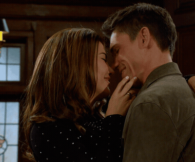 A Man And A Woman Are Touching Their Foreheads And Smiling GIF