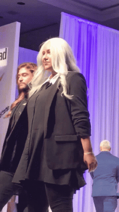 A Man And A Woman Are Walking Down A Runway At A Fashion Show GIF