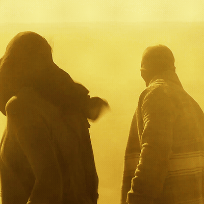 A Man And A Woman Are Walking In The Sun GIF