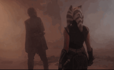 A Man And A Woman Are Walking Through A Foggy Area GIF