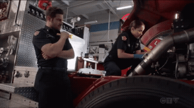 A Man And A Woman Are Working On A Fire Truck With A Ctv Logo In The Background GIF
