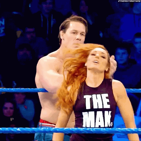 A Man And A Woman Are Wrestling In A Ring And The Woman Is Wearing A Tank Top That Says The Man GIF