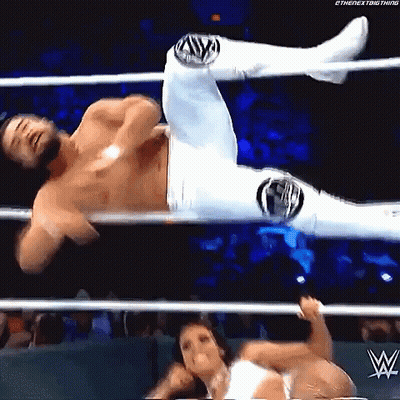 A Man And A Woman Are Wrestling In A Wrestling Ring . The Woman Is Holding The Man 'S Leg . GIF