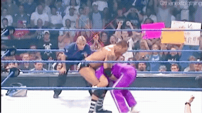 A Man And A Woman Are Wrestling In A Wrestling Ring With A Crowd Watching . GIF
