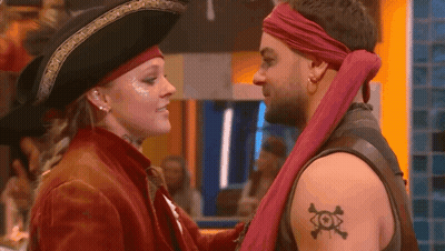 A Man And A Woman Dressed As Pirates Are Looking At Each Other . GIF