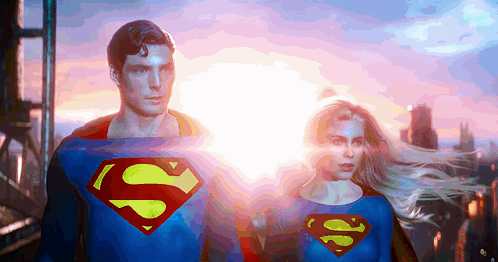 A Man And A Woman Dressed In Superman 'S Costumes GIF