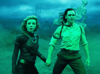 A Man And A Woman Holding Hands In A Field GIF