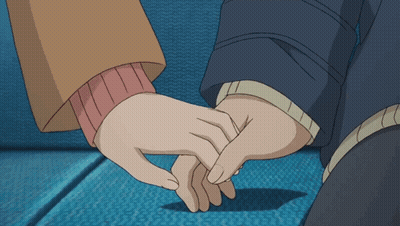 A Man And A Woman Holding Hands On A Blue Couch GIF
