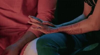A Man And A Woman Holding Hands With Henna On Their Arms GIF