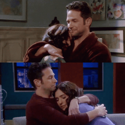 A Man And A Woman Hugging Each Other In A Living Room GIF