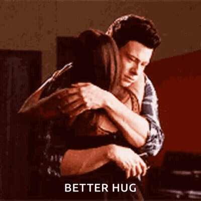 A Man And A Woman Hugging Each Other With The Words `` Better Hug '' Written On The Bottom . GIF