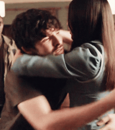 A Man And A Woman Hugging Each Other With Their Eyes Closed GIF