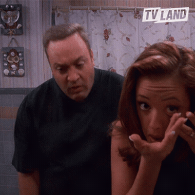 A Man And A Woman In A Bathroom With A Tv Land Sign On The Wall GIF