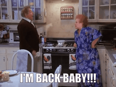 A Man And A Woman In A Kitchen With The Words " I 'M Back Baby " GIF