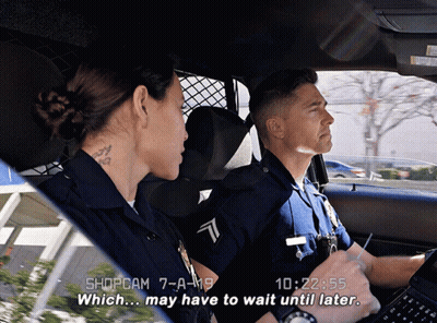 A Man And A Woman In A Police Car With The Time Of 10:22 On The Screen GIF