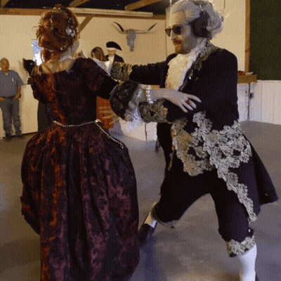A Man And A Woman In Costume Are Dancing Together GIF