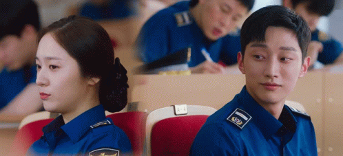A Man And A Woman In Police Uniforms Are Sitting In A Lecture Hall . GIF