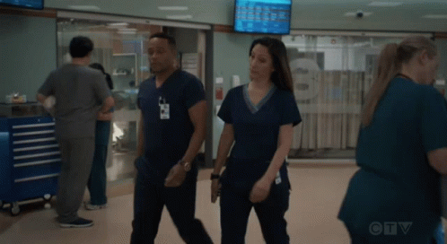 A Man And A Woman In Scrubs Are Walking In A Hospital Hallway With A Ctv Logo In The Background GIF