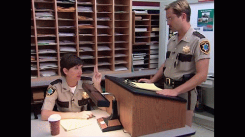 A Man And A Woman In Sheriff 'S Uniforms Talking GIF