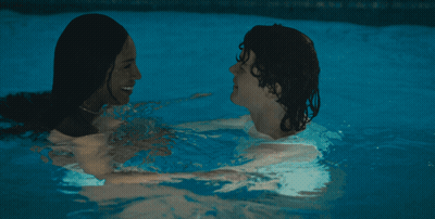 A Man And A Woman Kissing In A Swimming Pool GIF