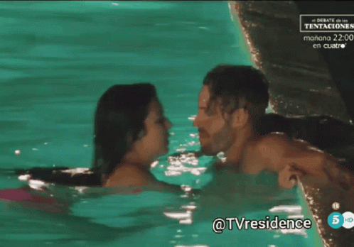 A Man And A Woman Kissing In A Swimming Pool With A Tv Residence Logo In The Corner GIF