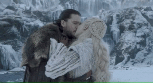 A Man And A Woman Kissing In Front Of A Waterfall . GIF