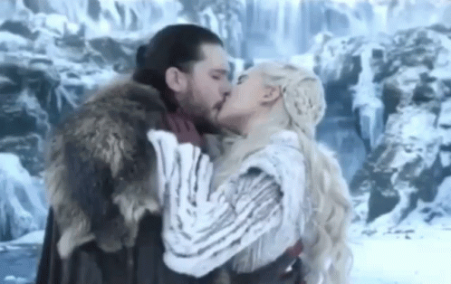 A Man And A Woman Kissing In Front Of A Waterfall . GIF