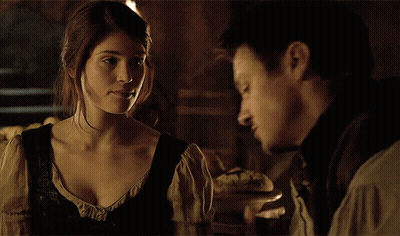 A Man And A Woman Look At Each Other In A Dark Room GIF