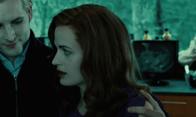 A Man And A Woman Looking At Each Other In A Dark Room GIF