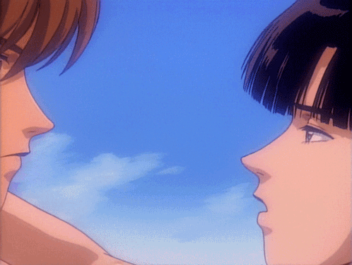 A Man And A Woman Looking At Each Other With A Blue Sky Behind Them GIF