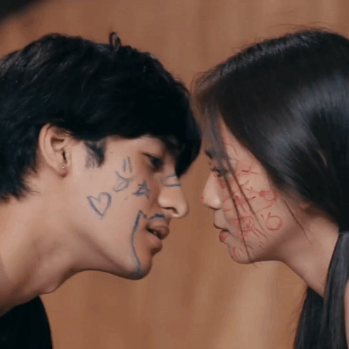 A Man And A Woman Looking At Each Other With Hearts And Stars Drawn On Their Faces GIF