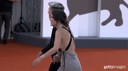 A Man And A Woman On A Red Carpet With Getty Images Written On The Bottom GIF