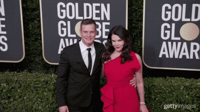 A Man And A Woman Pose On The Red Carpet At The Golden Globe Award GIF