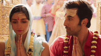 A Man And A Woman Praying In A Temple GIF