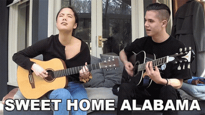 A Man And A Woman Singing Sweet Home Alabama On Guitars GIF