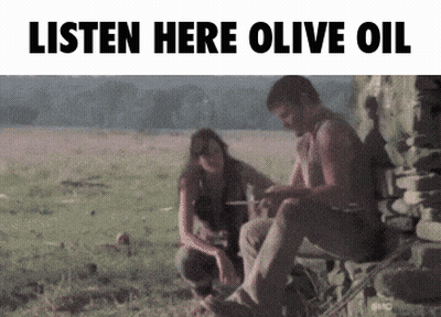 A Man And A Woman Sit In A Field With The Words Listen Here Olive Oil GIF