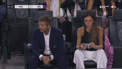A Man And A Woman Sit In A Stadium Watching A Soccer Game With The Score Of Mia 3 1 Orl GIF