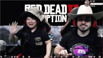 A Man And A Woman Sit In Front Of A Red Dead Redemption Screen GIF