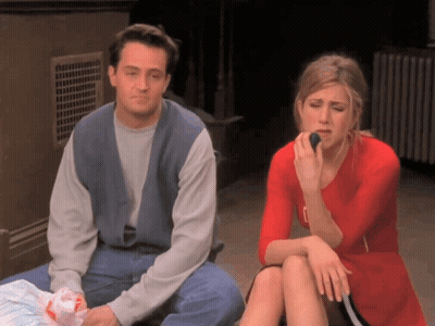 A Man And A Woman Sit Next To Each Other Eating GIF