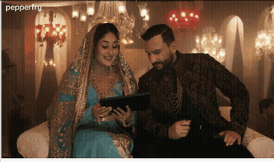 A Man And A Woman Sit On A Couch Looking At A Tablet And The Word Pepperfry Is On The Bottom GIF