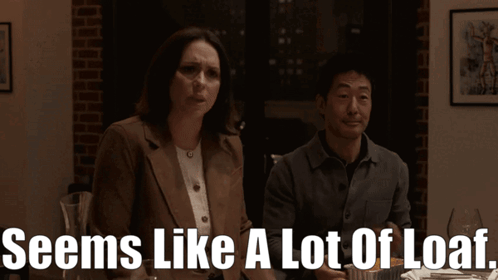 A Man And A Woman Sitting At A Table With The Words Seems Like A Lot Of Loaf Below Them GIF