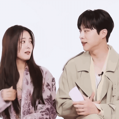 A Man And A Woman Sitting Next To Each Other GIF