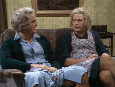 A Man And A Woman Sitting On A Couch Talking GIF